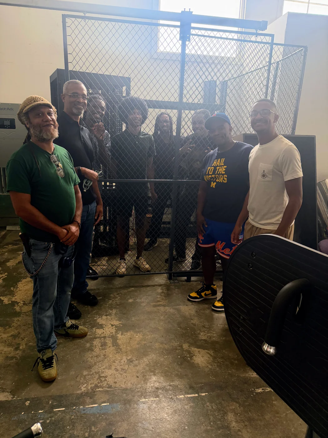 AARI scholars and partners gathered around the secured server cage at the solar-powered Data Center Site #2 co-location facility.
